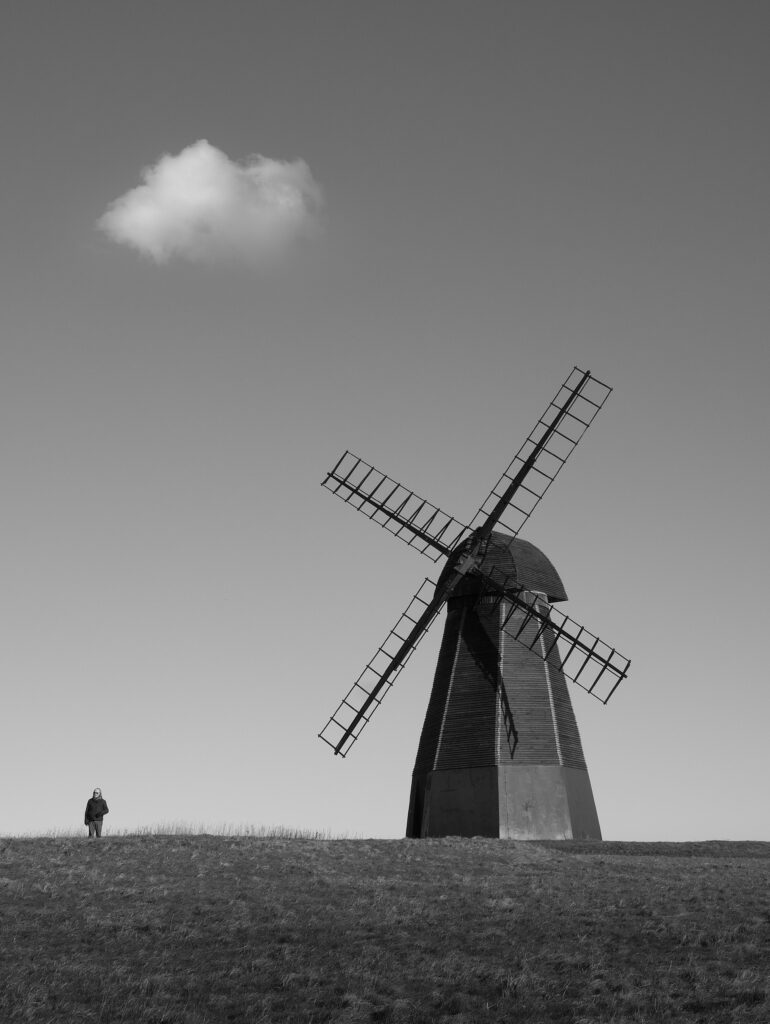 An Old Windmill and a Man on a Field